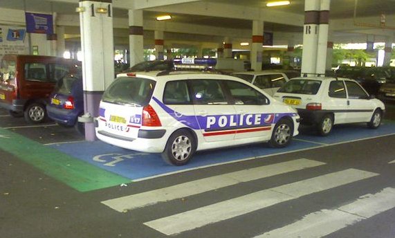 Une voiture de la police garée sur une place pour handicapé!