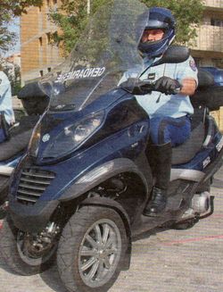 Un gendarme avec une bonne tête de vainqueur sur son scooter mp3
