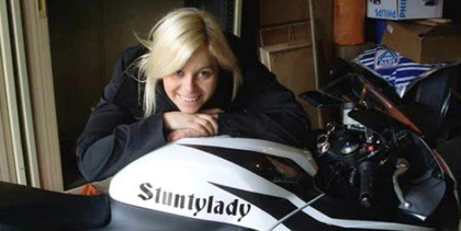Jolie blonde qui pose sur sa moto de stunt