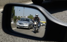 Photo d'un rétroviseur automobile dans lequel on voit une moto