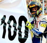 Prévisualisation de la photo de Rossi qui tient fièrement la banderole représentant ses 100 victoires en Grand-Prix