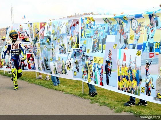 Prévisualisation de la photo de Rossi devant sa la banderole représentant ses 100 victoires en Grand-Prix