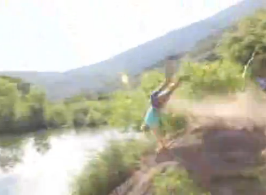 Une blonde veut sauter dans un lac en vélo